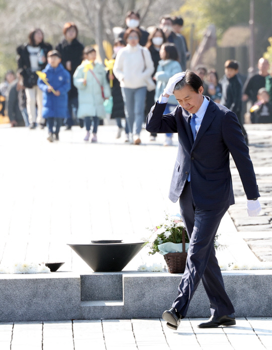 조국 전 법무부 장관이 설 연휴 마지막 날인 12일 경남 김해시 진영읍 봉하마을 고(故) 노무현 전 대통령 묘역을 참배, 너럭바위로 이동하며 머리카락을 만지고 있다.   [연합뉴스]